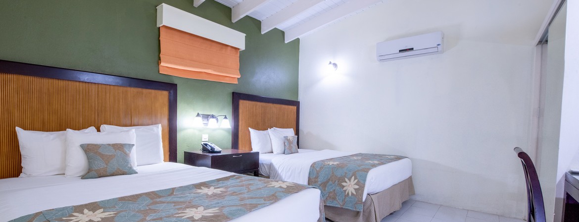 a room with two beds and a phone on the wall