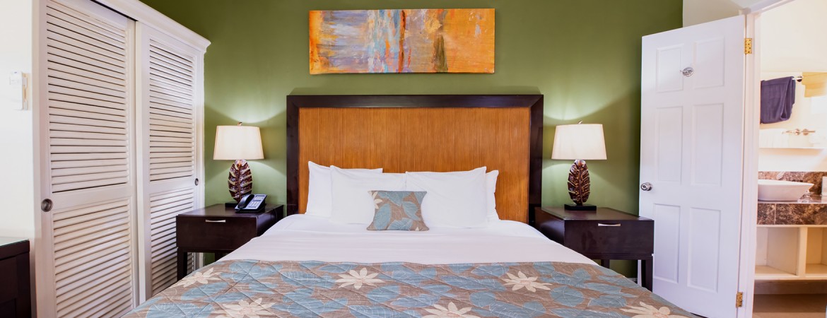 a bed with a wood headboard and lamp on a table