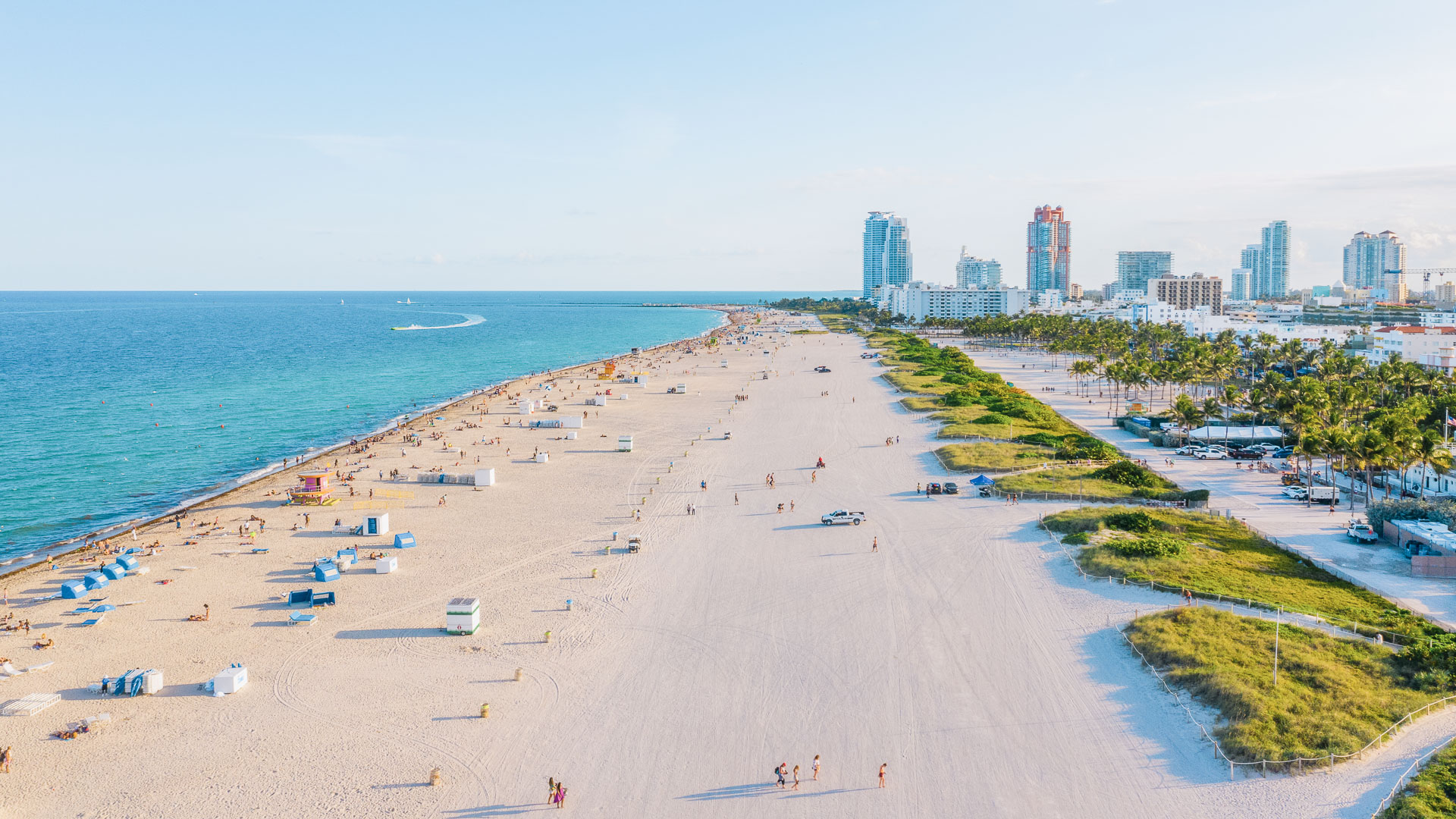 a beach with many people and buildings