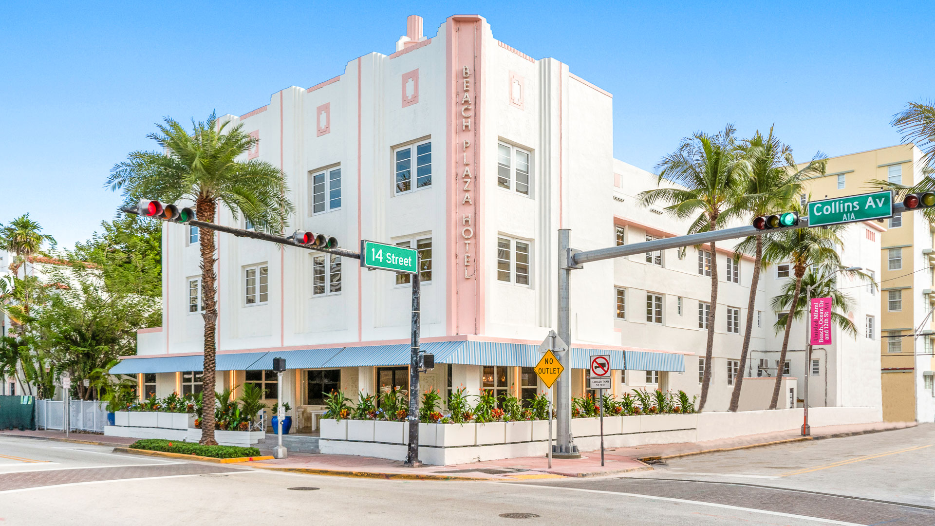 a building with palm trees and a street sign