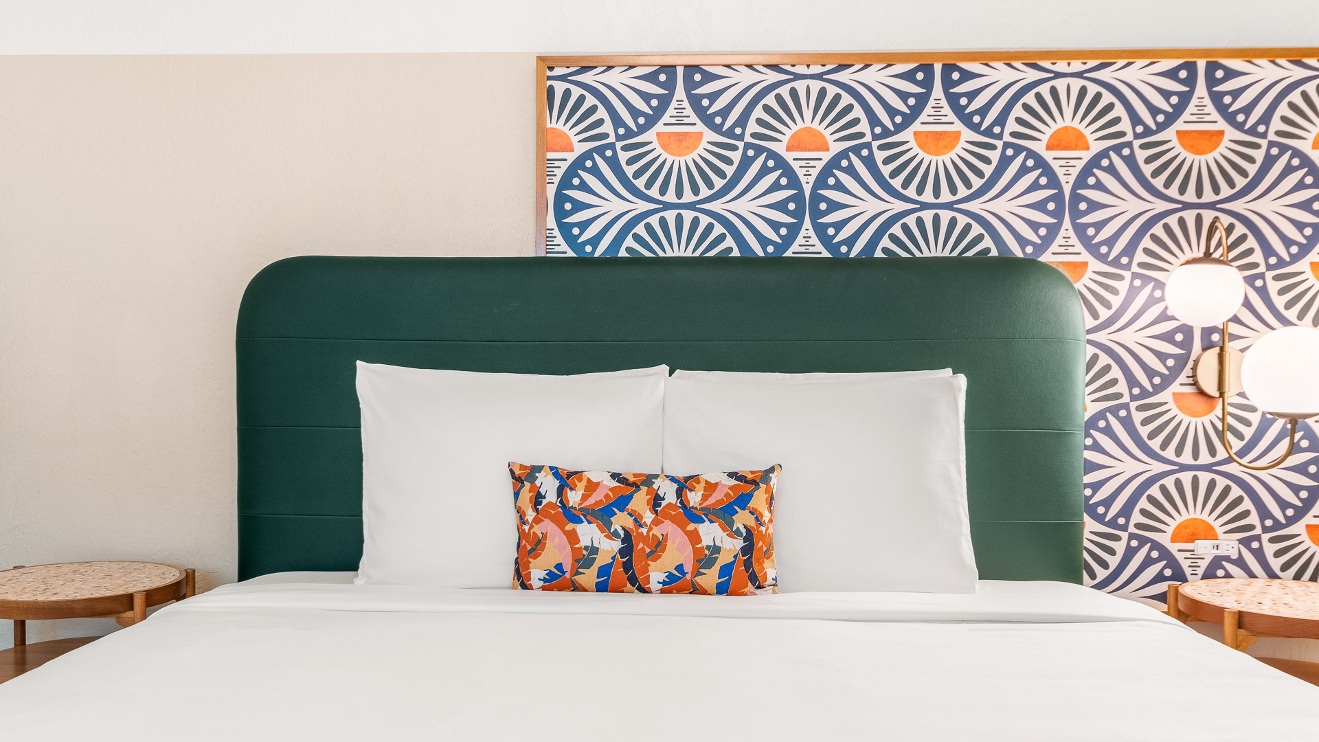 a bed with pillows and a colorful pillow on it