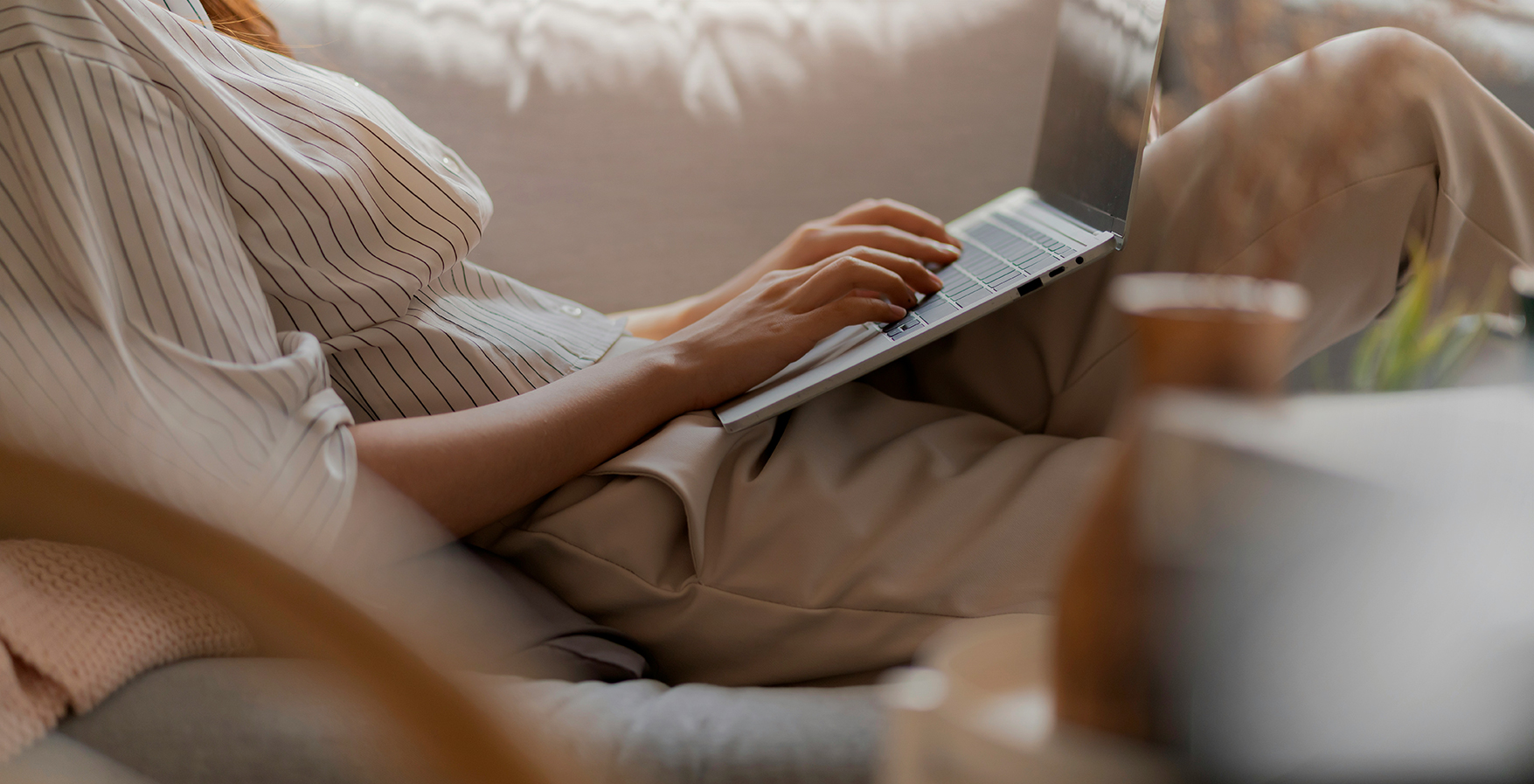 a person sitting on a couch using a laptop