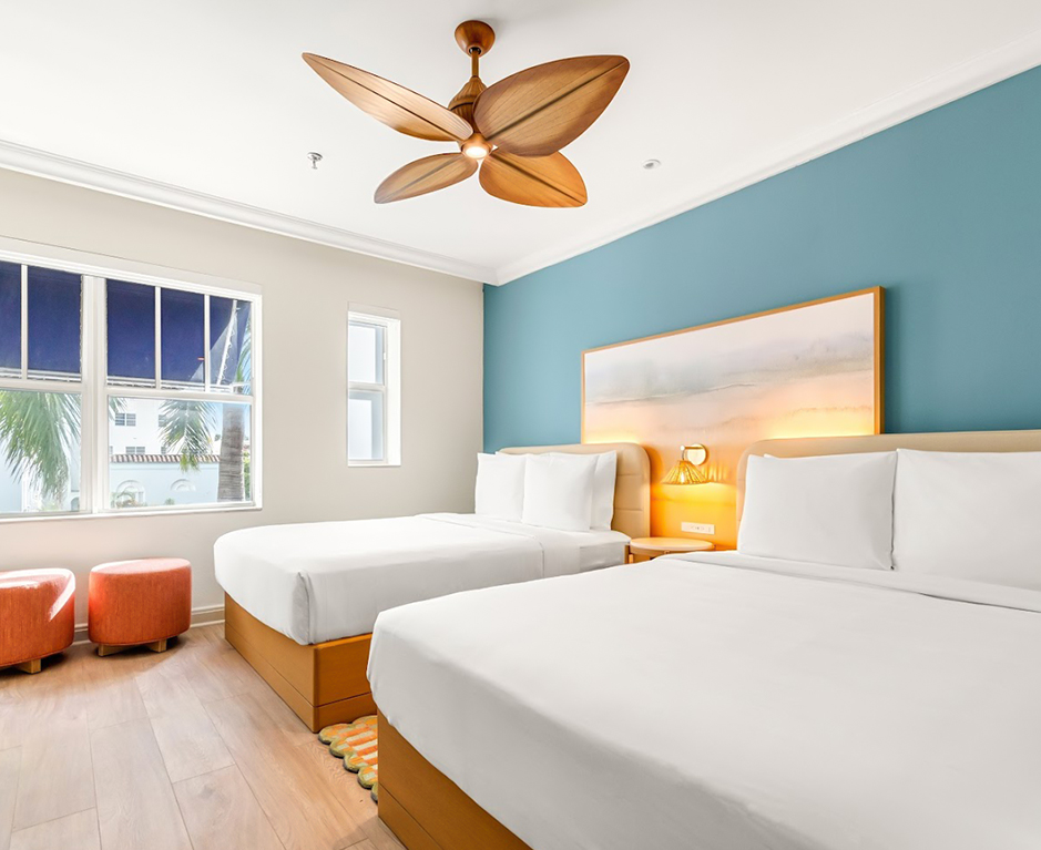 a room with two beds and a ceiling fan