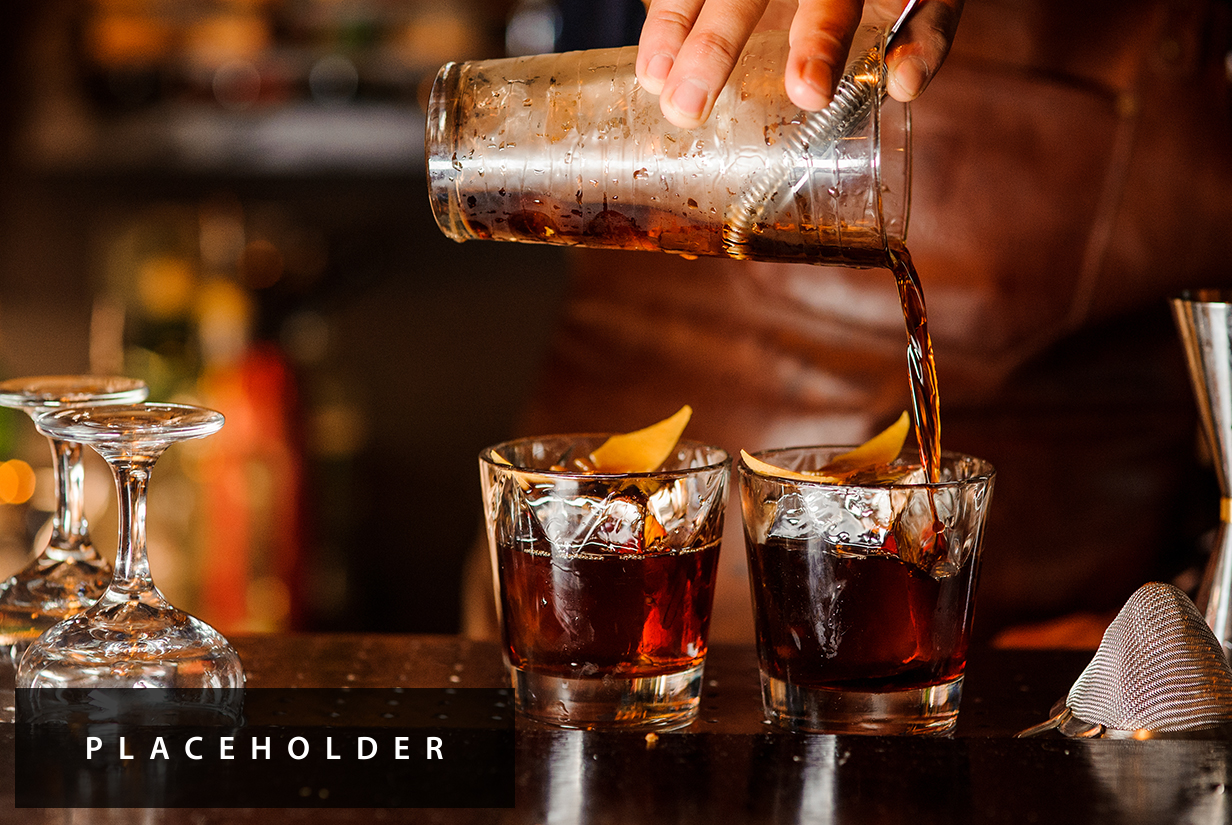 a person pouring a drink into two glasses