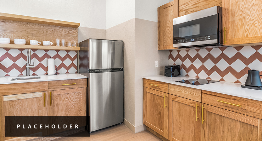 a kitchen with a stainless steel refrigerator and wooden cabinets