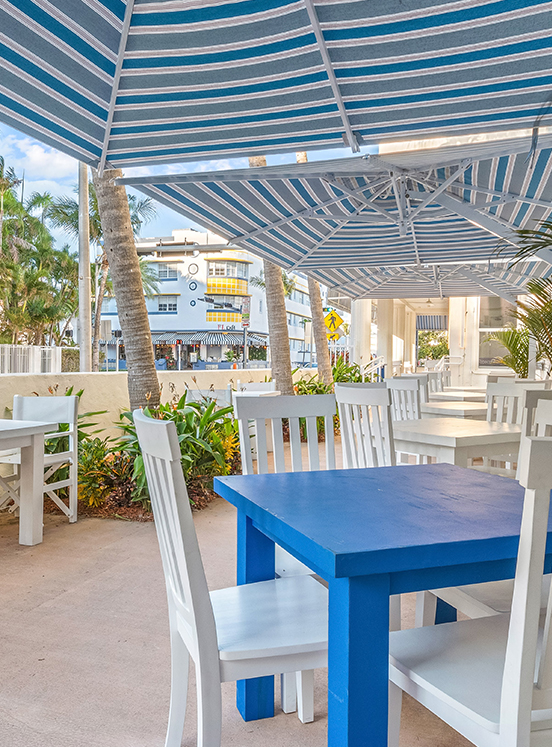 a blue table and chairs under a striped umbrella