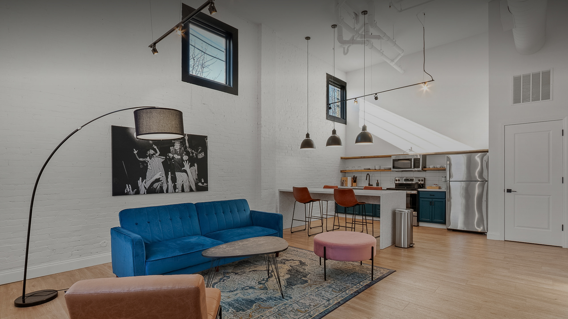 a living room with a blue couch and a kitchen