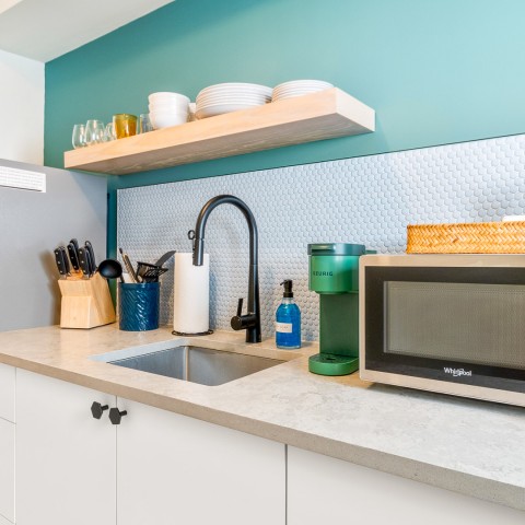 a kitchen counter with a microwave and a sink