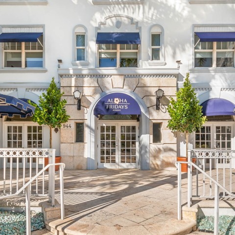 a building with blue awnings and a white railing
