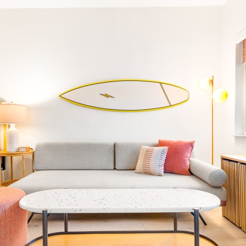 a living room with a surfboard on the wall