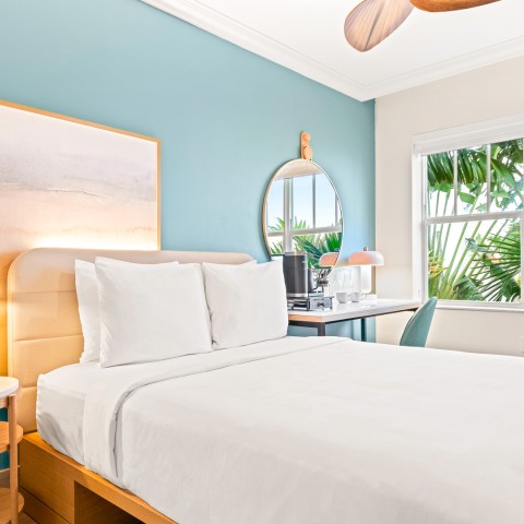 a bed with a fan and a table