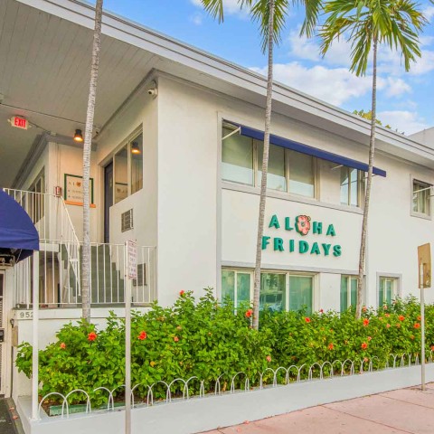 a building with palm trees and a sign