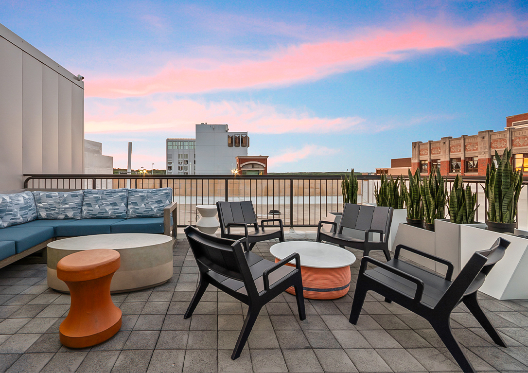 a patio with chairs and tables on a rooftop