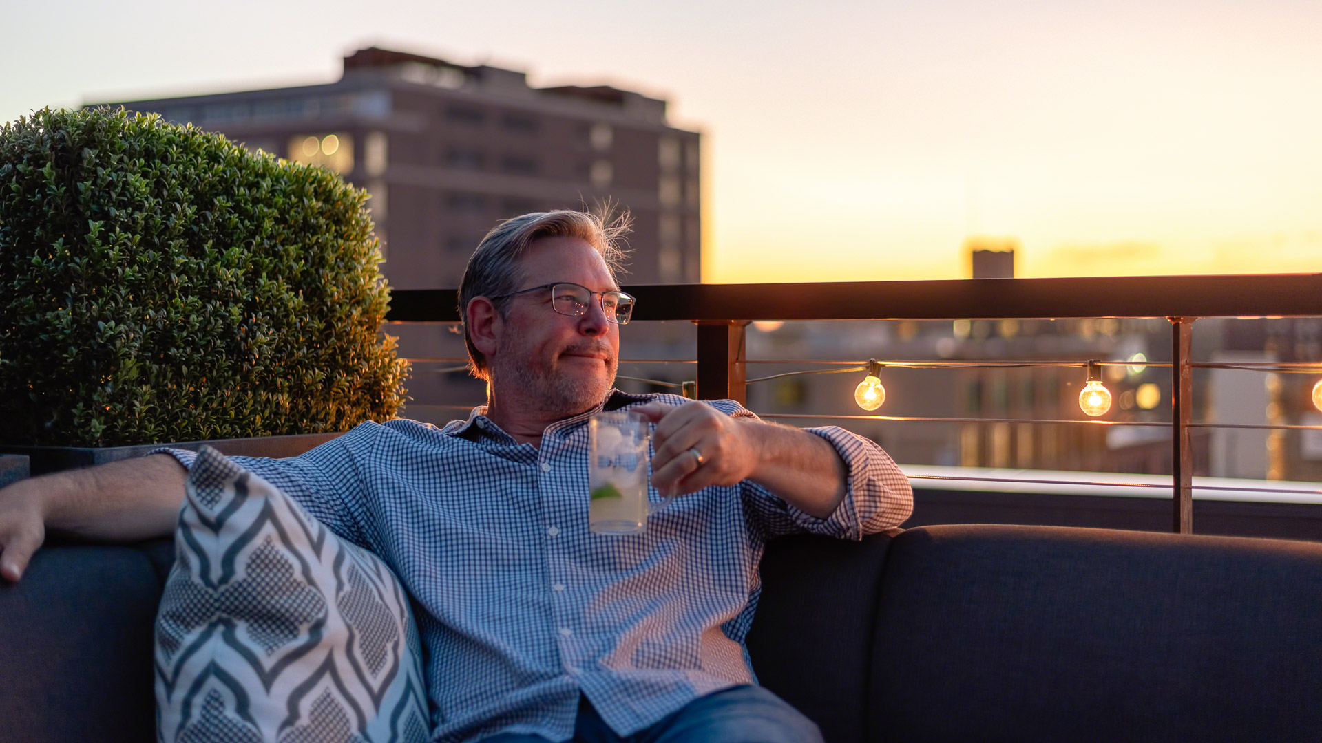 a man sitting on a couch holding a drink