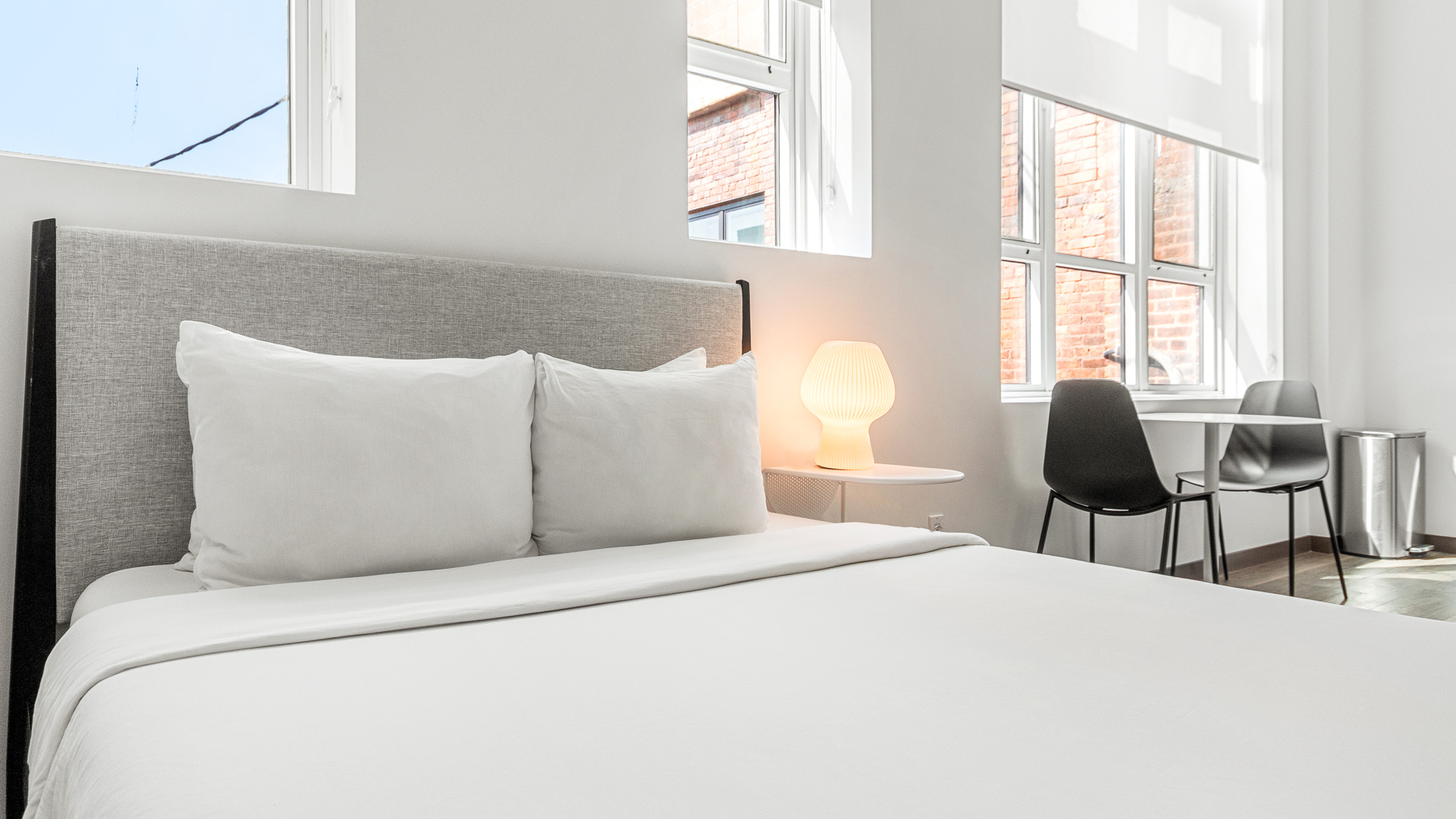 a bed with white sheets and a lamp