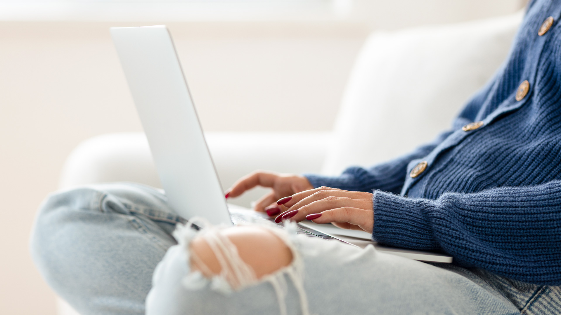 a woman sitting on a couch using a laptop