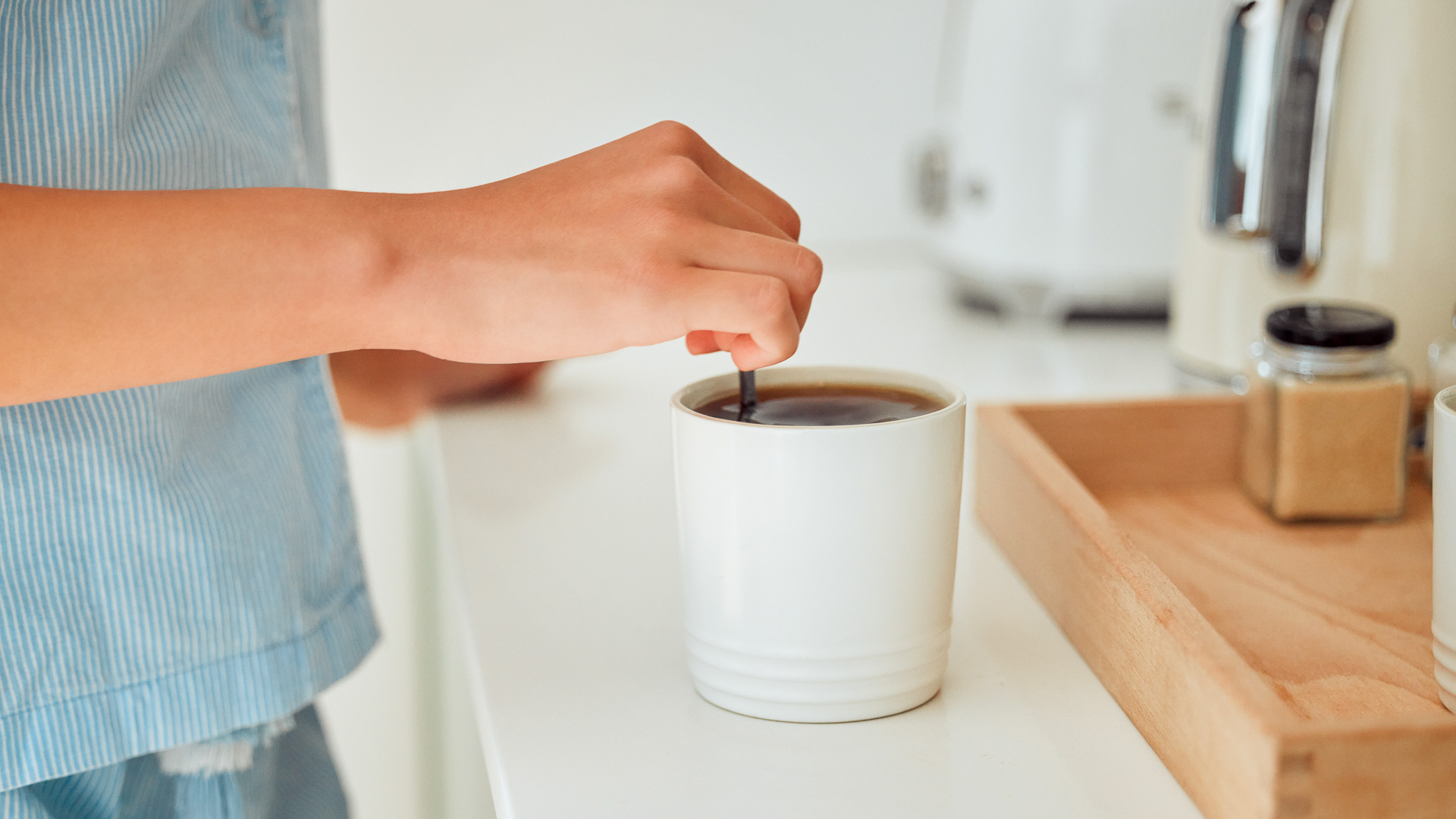 a person pouring a liquid into a cup