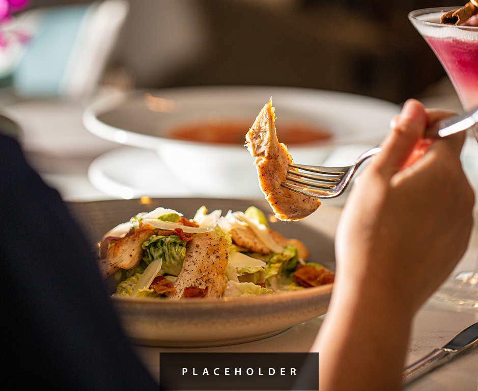 a person holding a fork over a plate of food