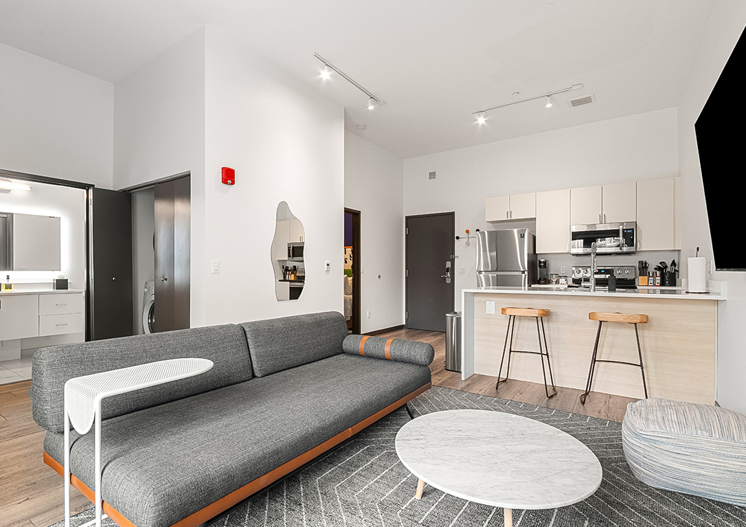 a living room with a couch and a kitchen