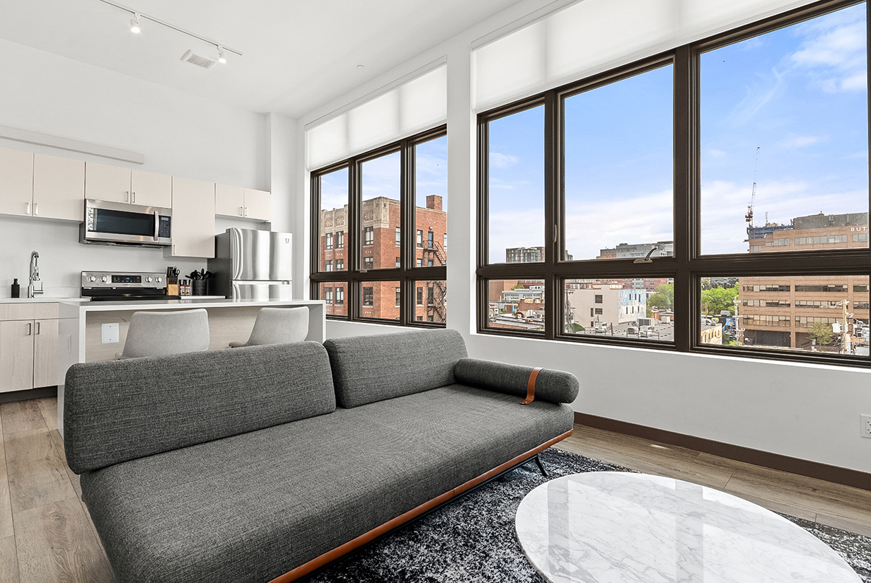 a living room with a couch and a kitchen