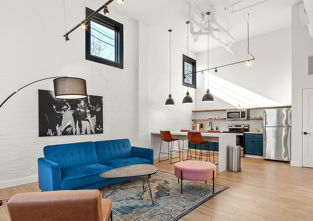 a living room with a blue couch and a kitchen