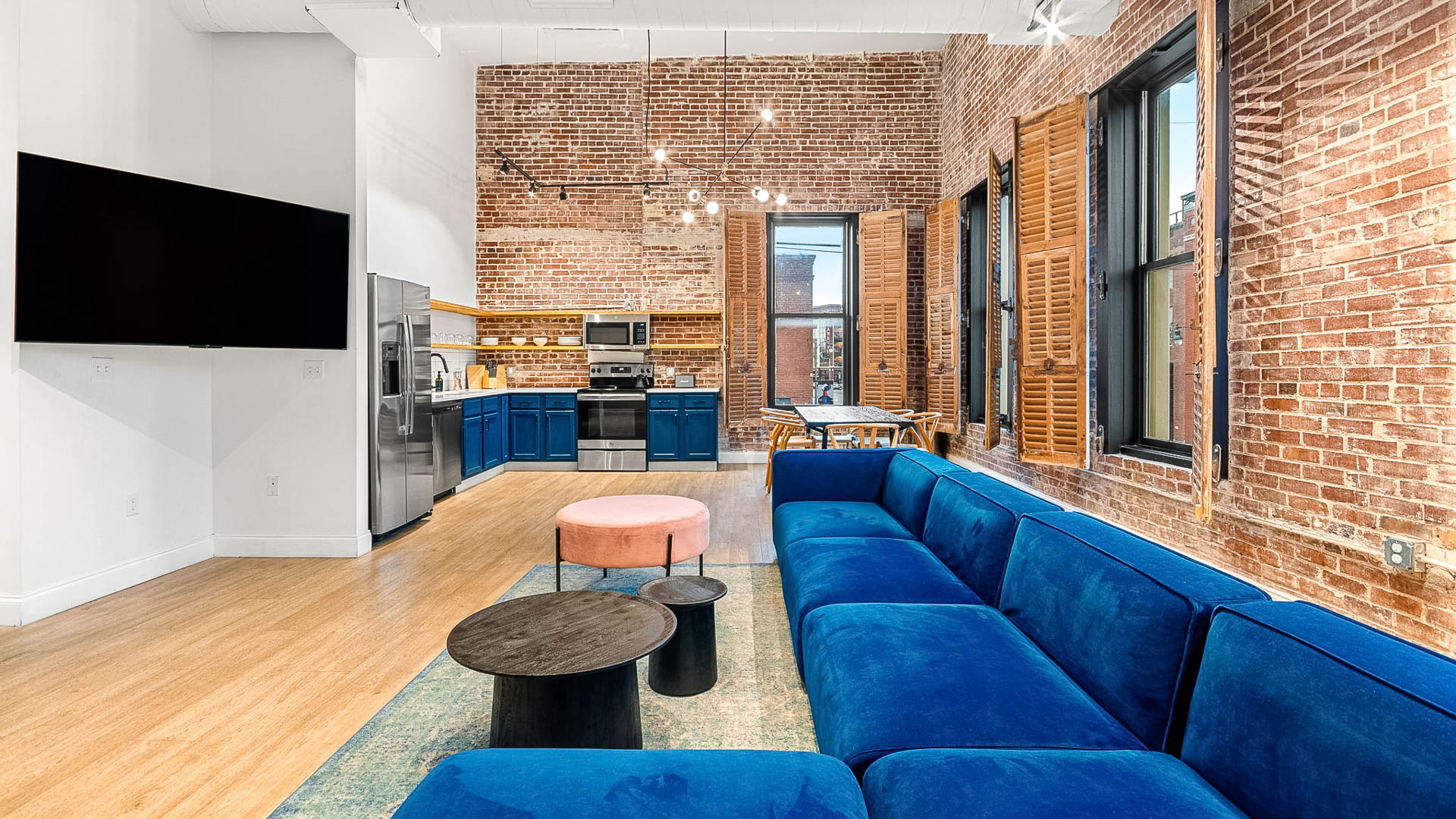 a living room with a blue couch and a brick wall