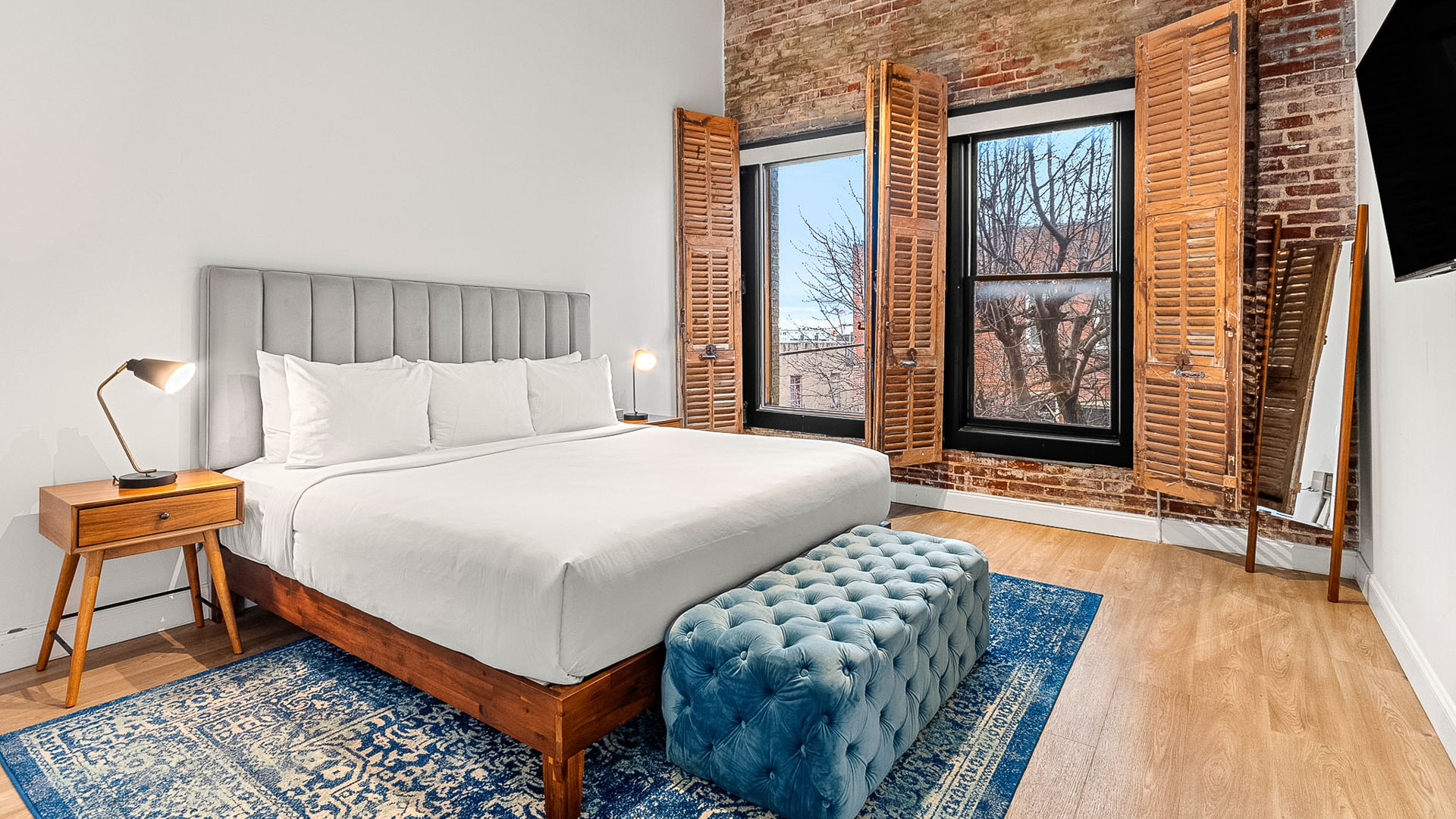 a bedroom with a bed and a blue ottoman