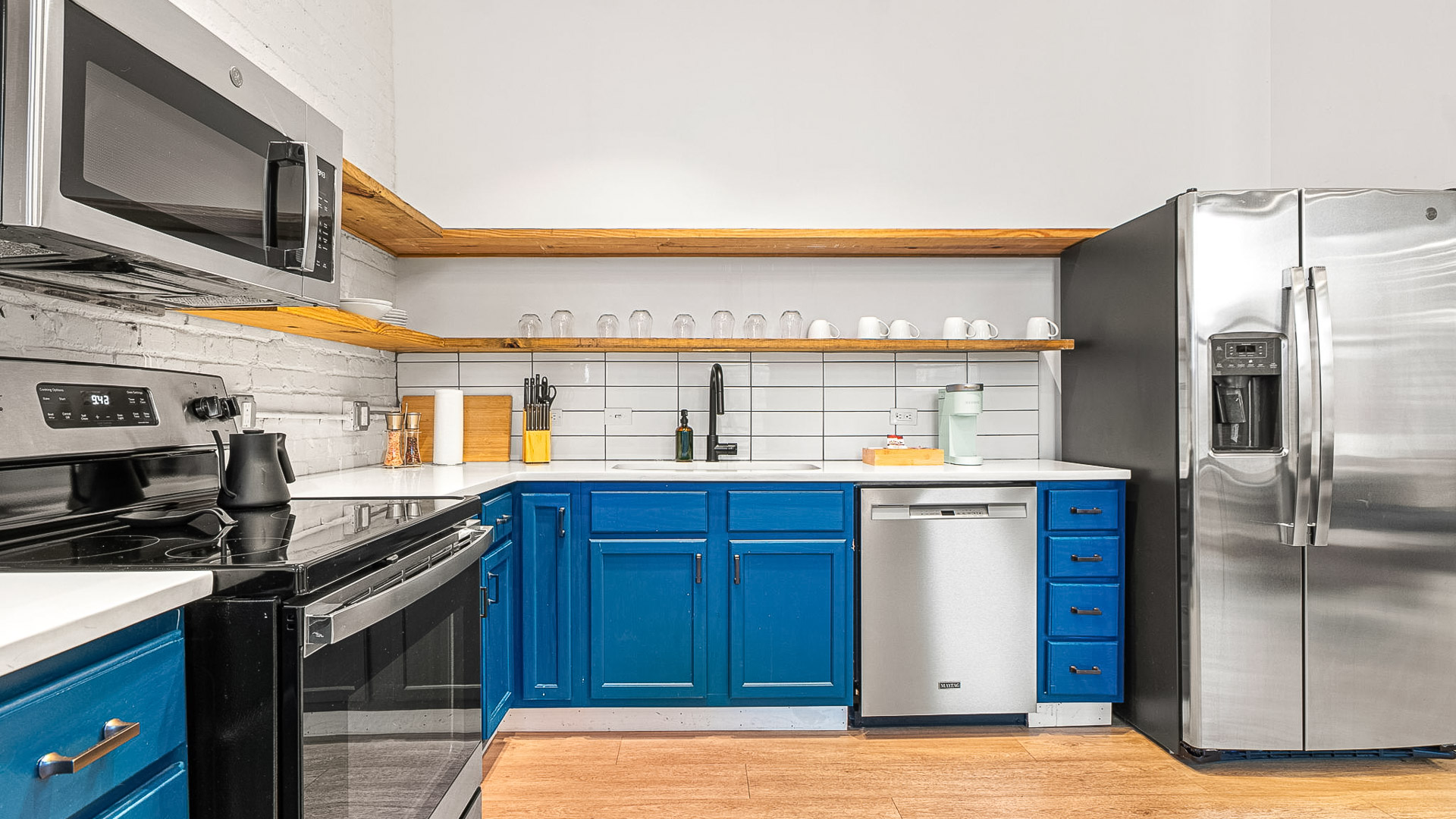 a kitchen with blue cabinets and a black refrigerator