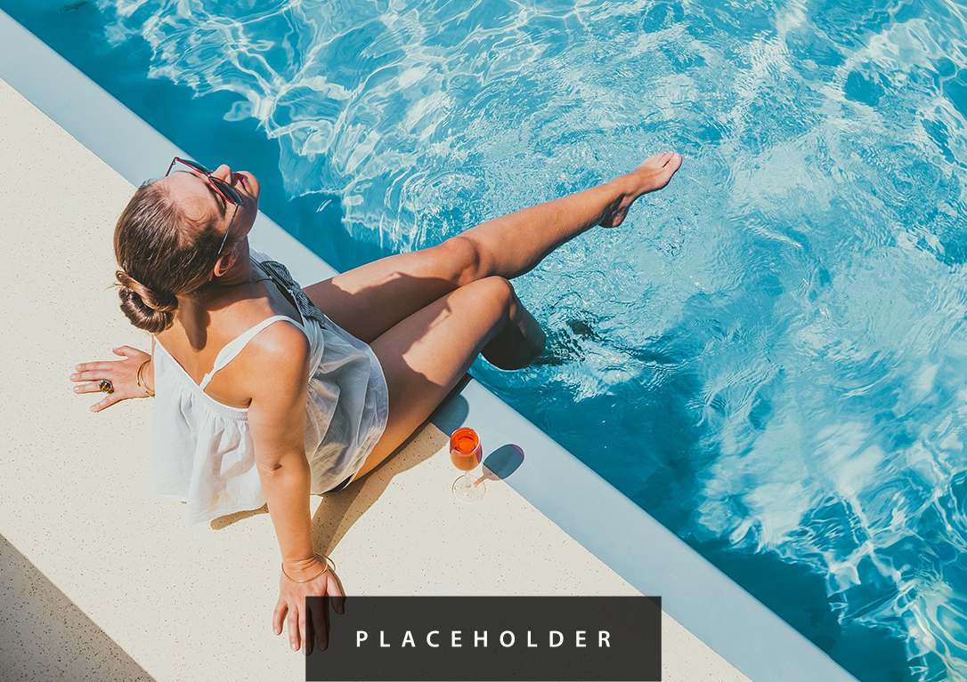 a woman sitting on a ledge of a pool