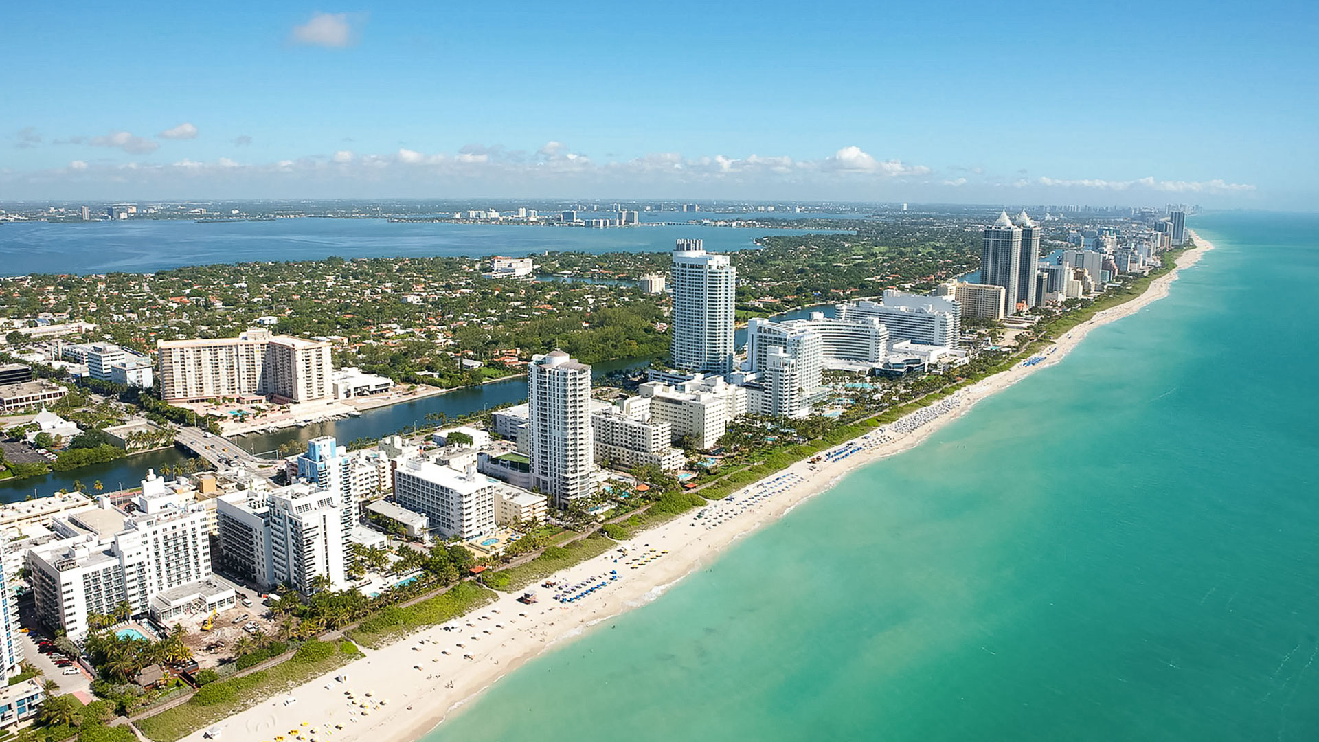 a beach with buildings and a body of water
