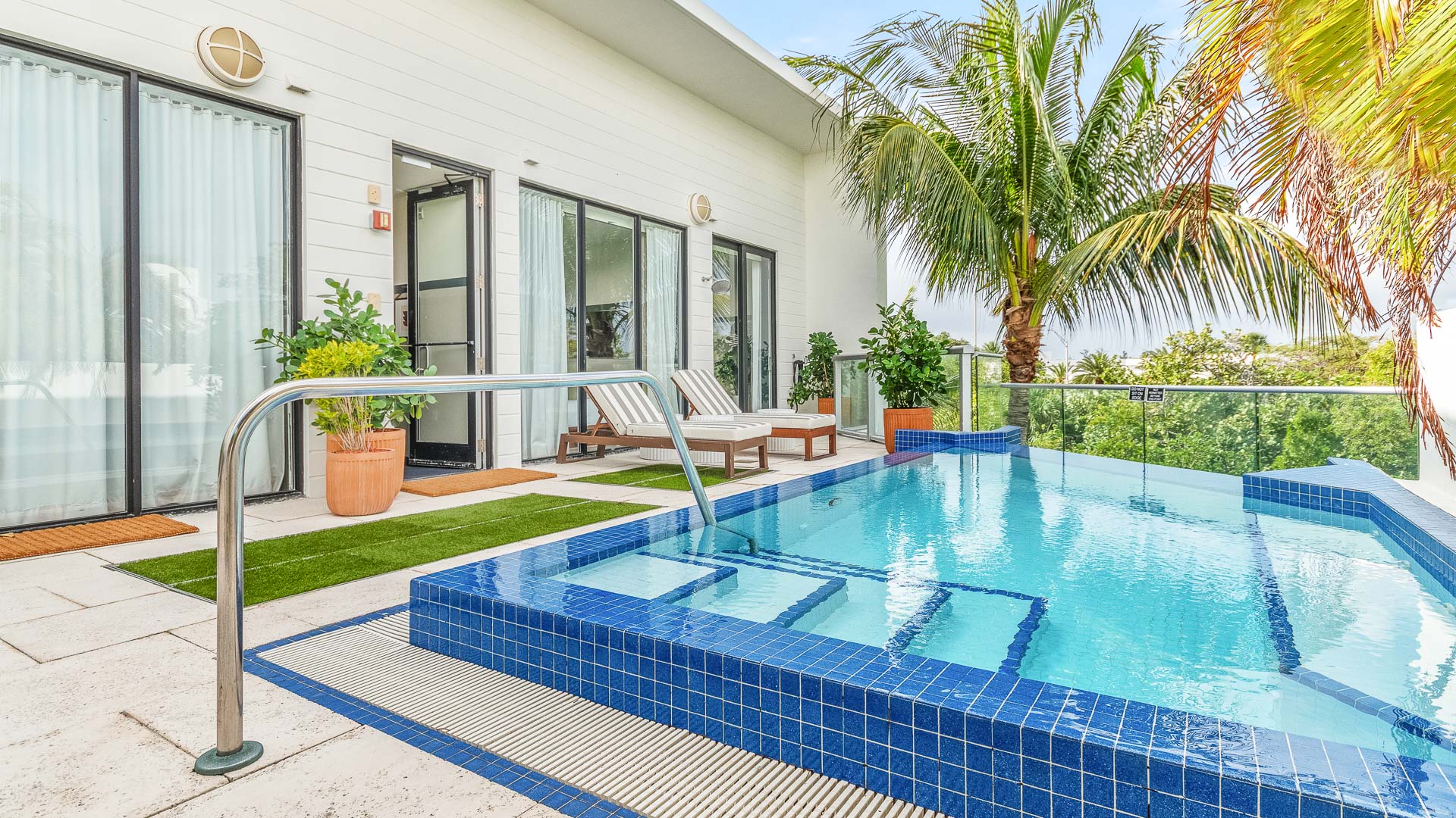 a pool with a deck chair and palm trees