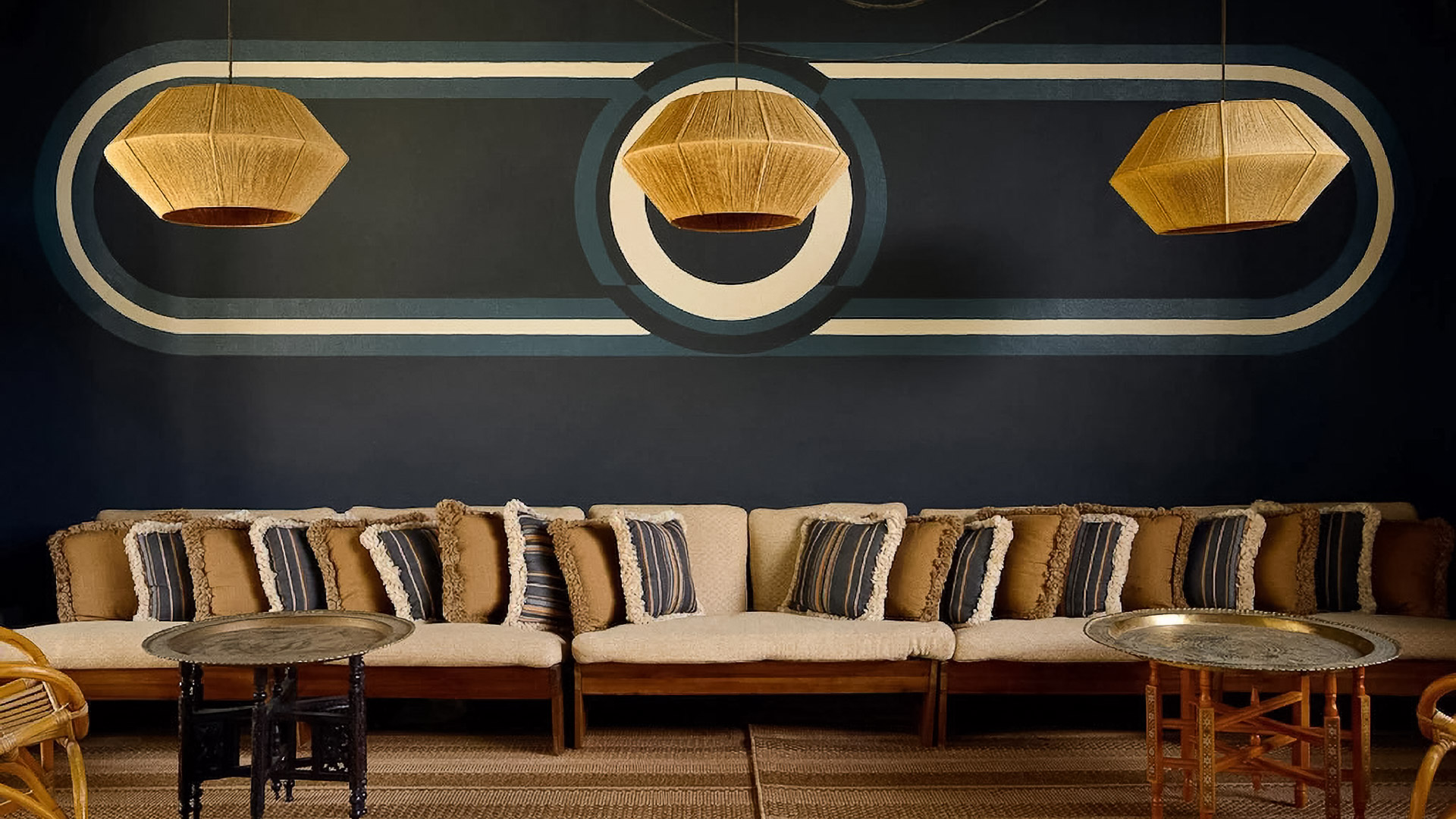 a couch with pillows and a table with lamps from it