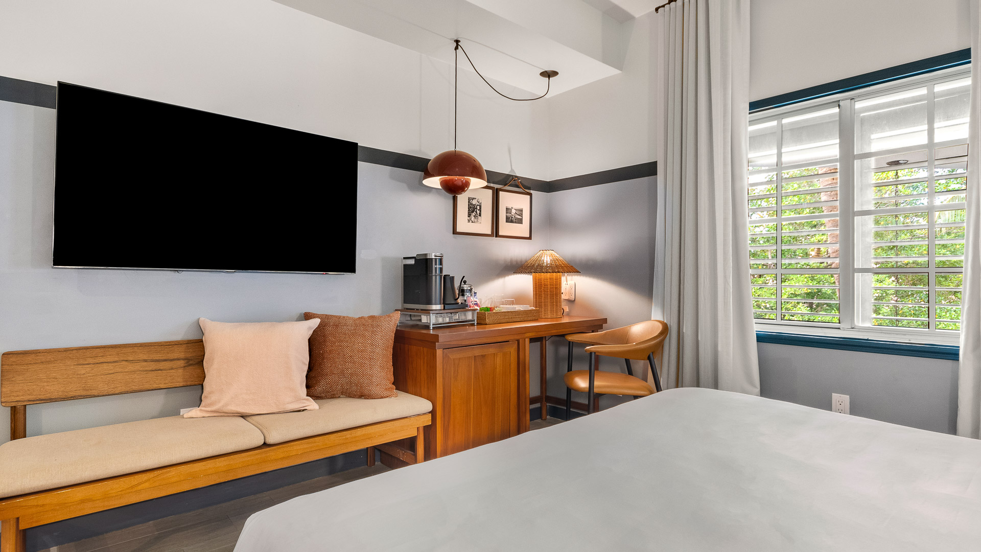 a room with a bed and a desk and a tv