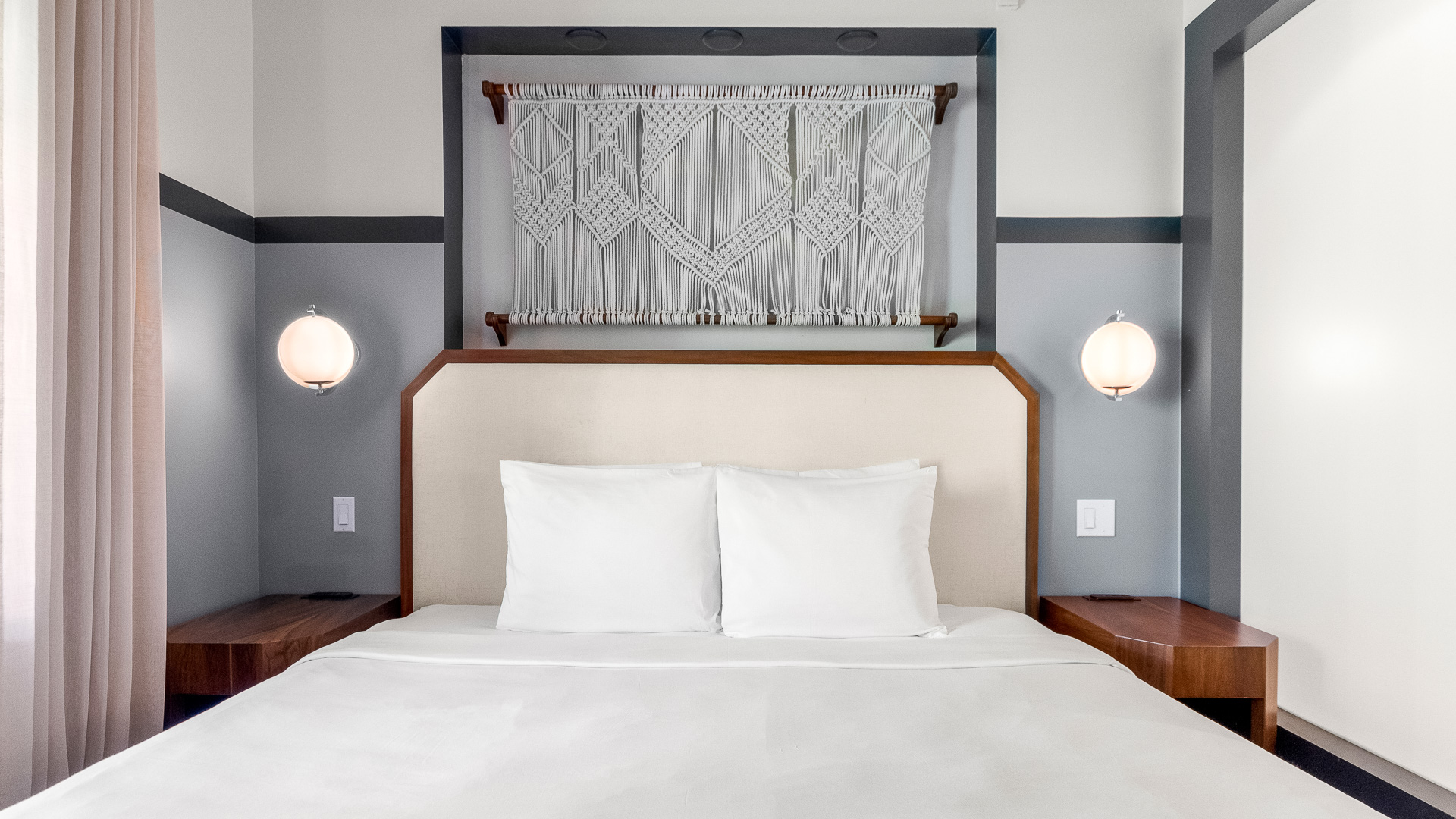 a bed with white sheets and a white curtain above it