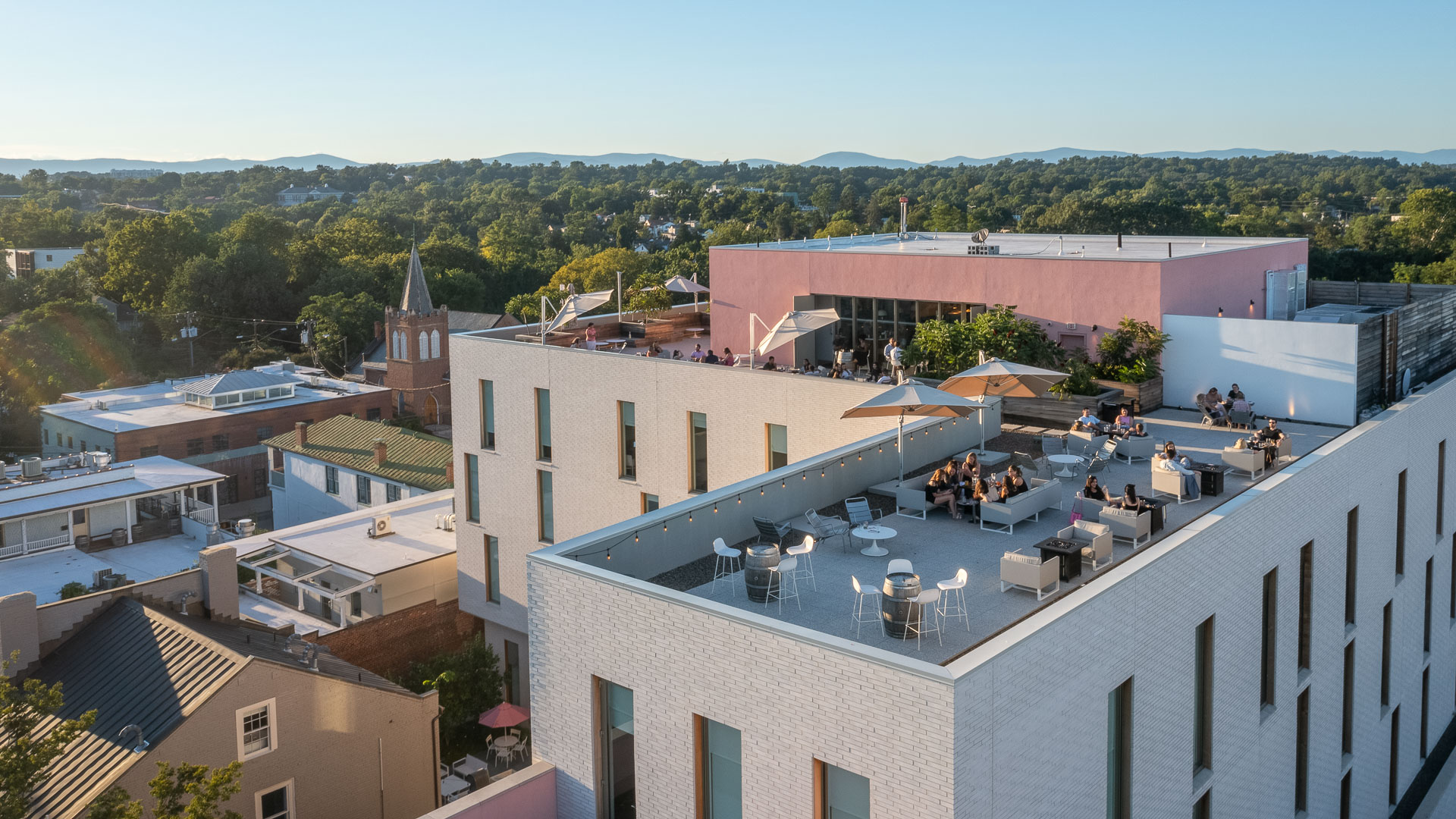 a rooftop of a building with tables and umbrellas