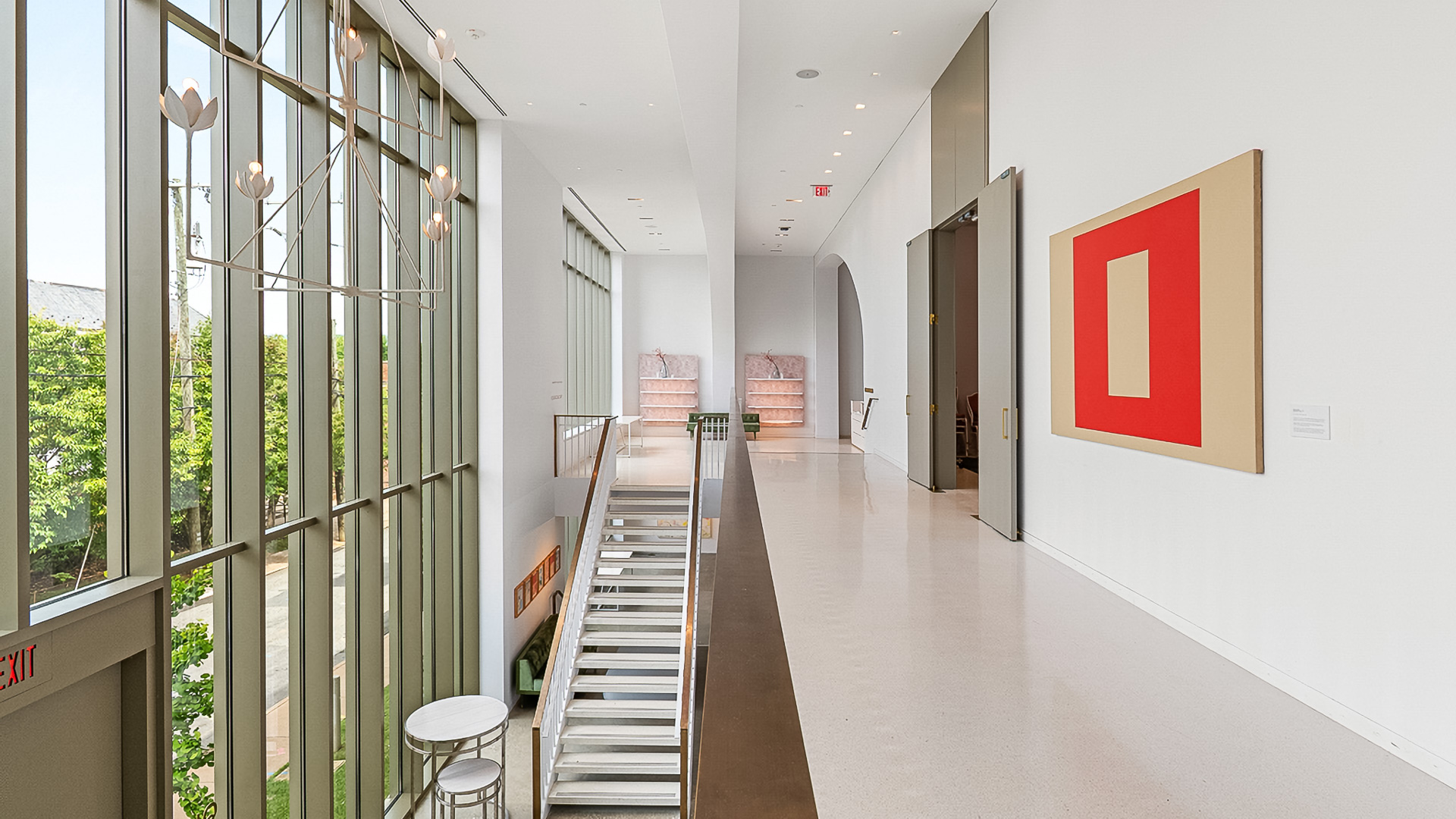 a hallway with a staircase and art on the wall