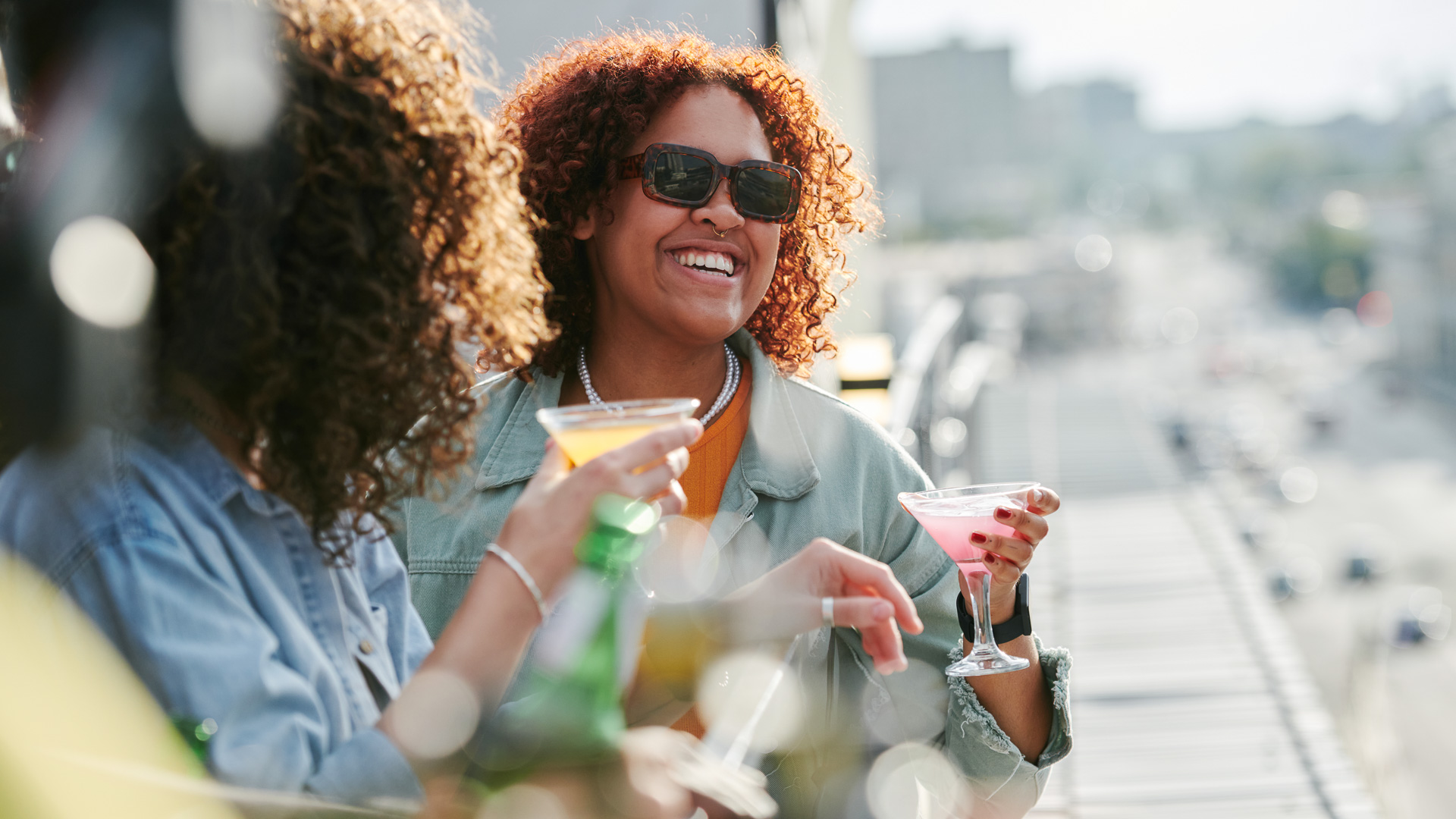 a group of women smiling and holding drinks