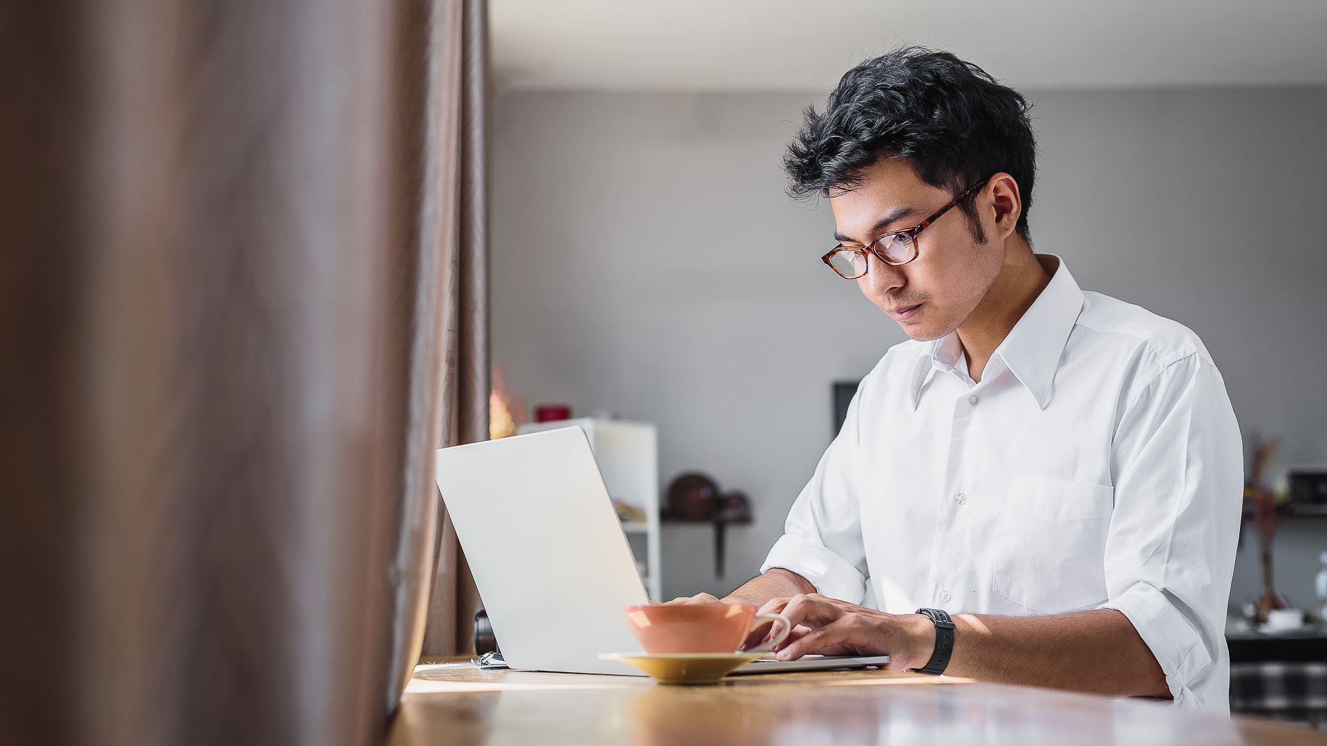 a man in glasses using a laptop