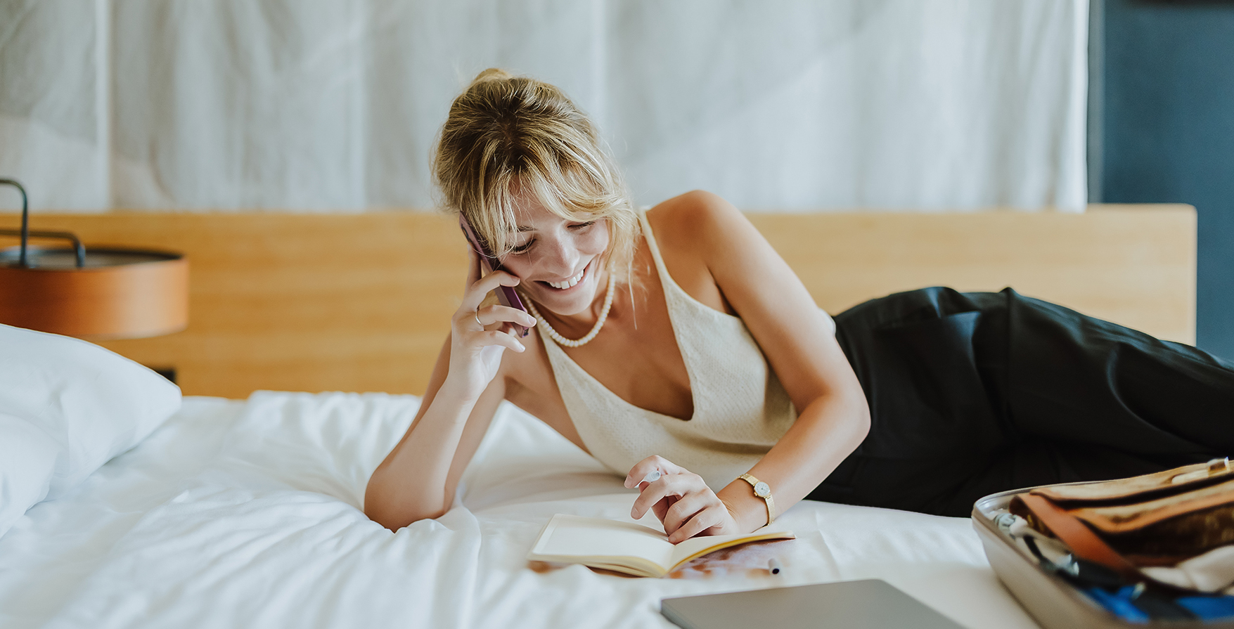 a woman lying on a bed and talking on the phone