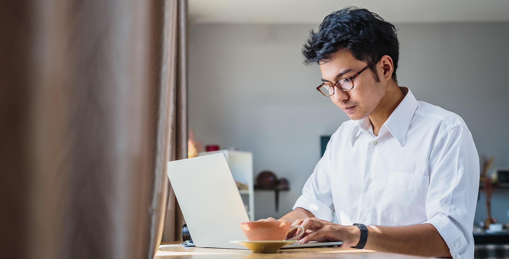 a man in glasses using a laptop