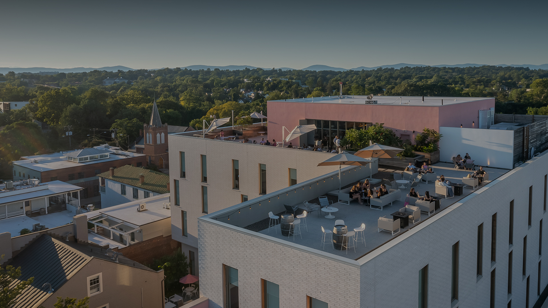 a rooftop of a building with tables and umbrellas