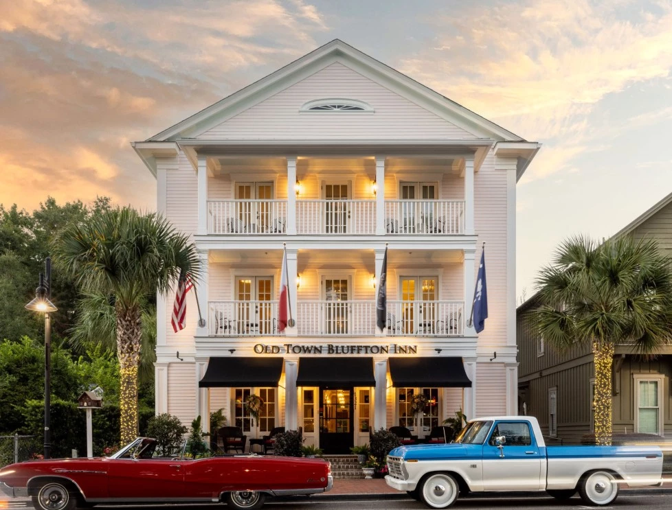 a white building with a red car parked in front of it