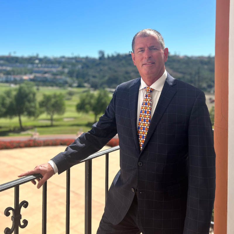 a man in a suit leaning on a railing