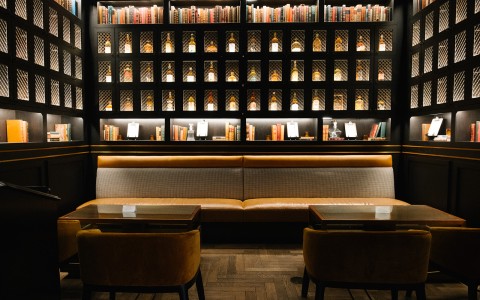 a room with a black wall and shelves with books