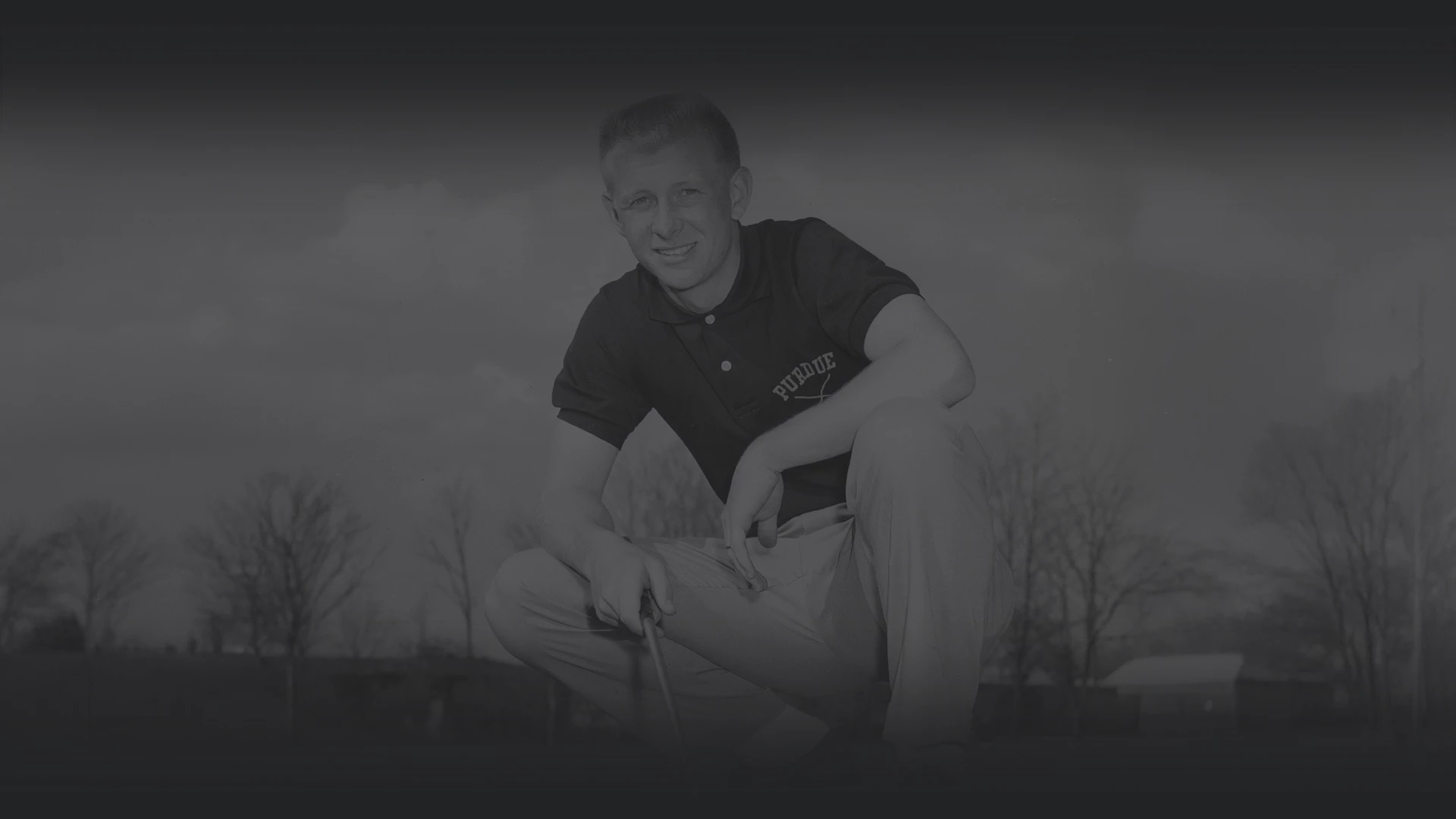 a man squatting on a golf course