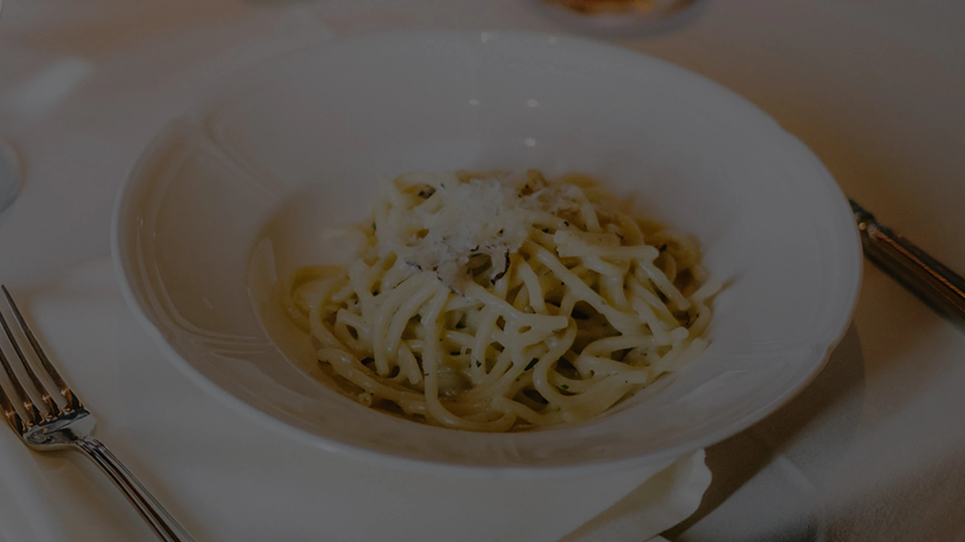 a bowl of spaghetti with cheese on top