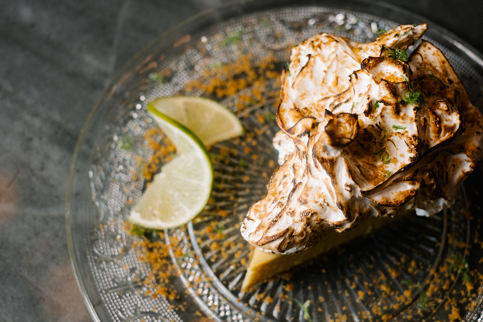 a pie with whipped cream and lime wedges