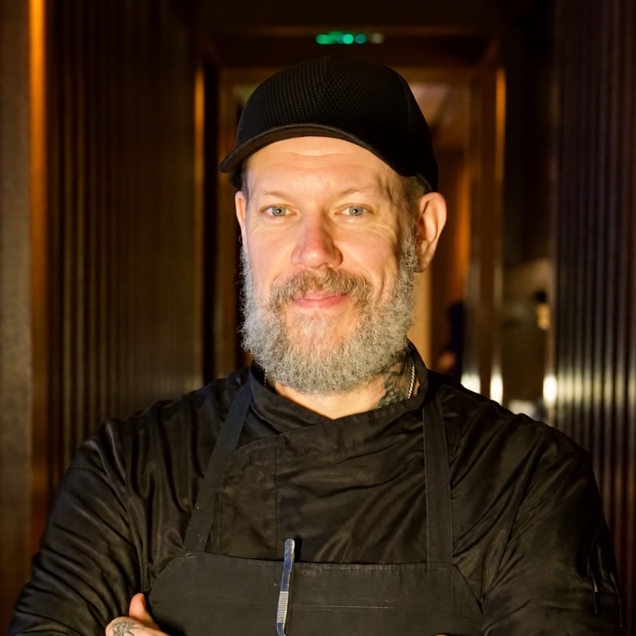 a man wearing a black apron and a hat
