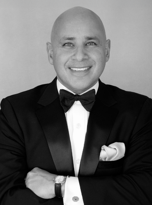 a man in a tuxedo smiling