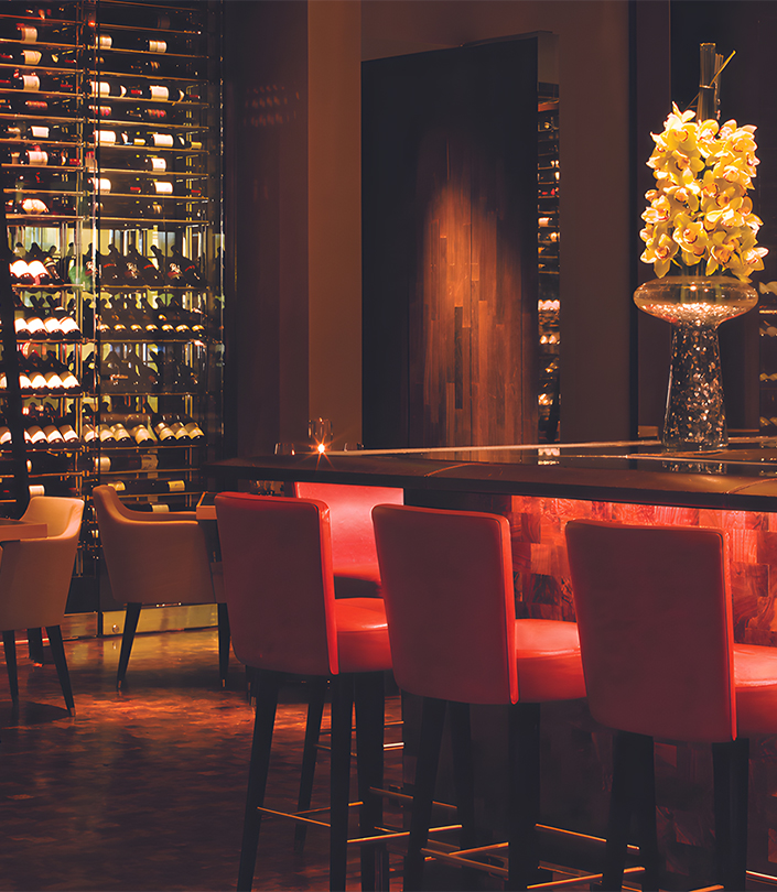 a room with a bar and wine bottles